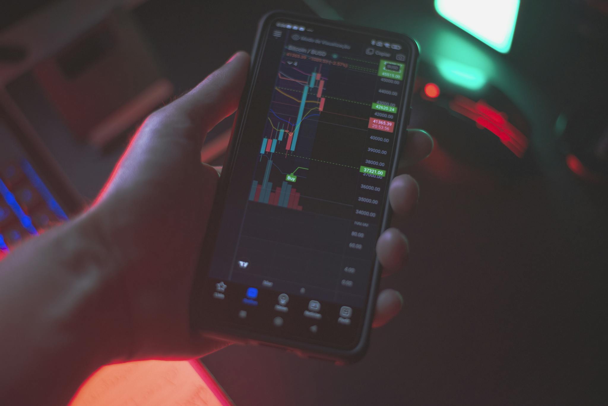 Hand holding smartphone displaying cryptocurrency trading app with financial data.